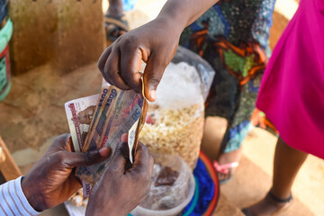 Cash, money or Nigerian currency exchanging hands during a business transaction with edible food in...