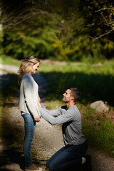 Were going to be parents. Shot of a man kneeling and touching his wifes stomach while enjoying a day in the park.