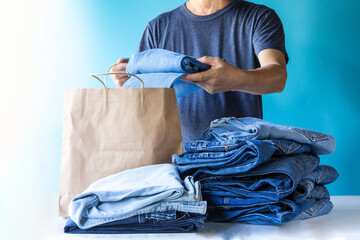 Man select jeans put into bag shop.concept  buy-sell jeans in shop, store and supermarket.