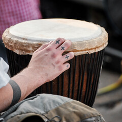 Male hand playing a djembe drum bongo African music instrument