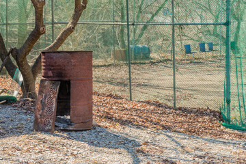 Rusted oil drum converted to outdoor fire place.
