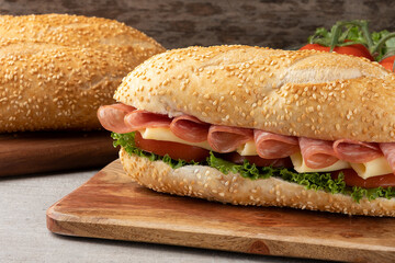 Baguette stuffed with salami, cheese, tomato and lettuce.