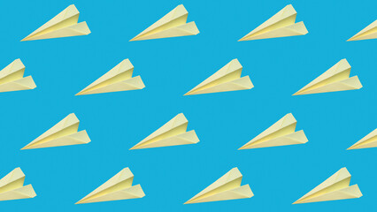 On a blue background, a pattern of yellow paper planes, origami. Close-up wallpapers and backgrounds.