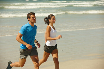 This couple takes being fit serious. Shot of a young couple jogging together on the beach.