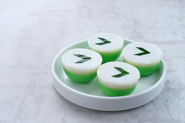 Kue Nona Manis, traditional Indonesian cake made from wheat flour, rice flour, sugar, salt, coconut milk, and pandan leaves, then steamed. Selected focus. 
