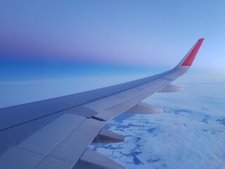 Obraz premium Wing of an airplane in the morning sky