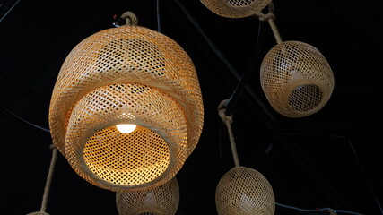 Bamboo lamp. Modern style woven bamboo ceiling lamp with dark background. Close focus and select...