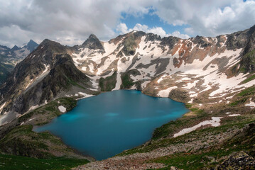 Naklejka na ściany i meble High-mountain lake in summer surrounded by mountain peaks, Dombai, Russia