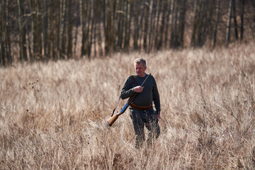 Hunter with rifle in the forest