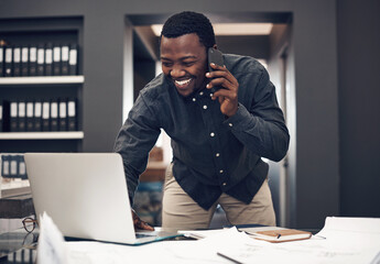 Let me open the file real quick.... Cropped shot of a handsome young male architect taking a phonecall while working on a laptop in a modern office.