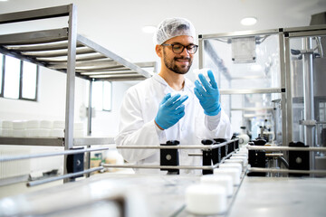 Technologist worker checking production of health care creme products for cosmetics industry.