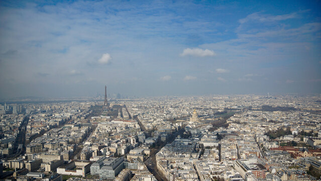 Ausblick vom Tour de Montparnasse auf den Eiffelturm und den Invalidendom sowie die D&auml;cher von Paris von oben mit kleinen Wolken