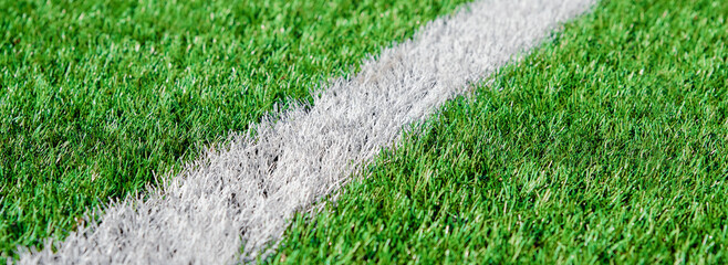 Part of football or soccer field close up, Artifical green grass with white border lines, Astroturf...