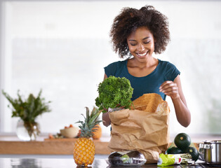 I hope the chef gets a kiss afterwards. Cropped shot of a young woman with some groceries. - Powered by Adobe