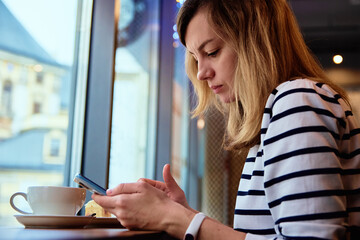 Woman hand use smartphone at cafe, surfing internet browser, have a coffee break. Online communication and social media