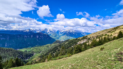 Fototapeta na wymiar Panoramic view from Frauenkogel on mountain peaks in the Karawanks and Julian Alps, Carinthia, Austria. Borders Austria, Slovenia, Italy. Triglav National Park. Alpine meadows in spring. Woodland