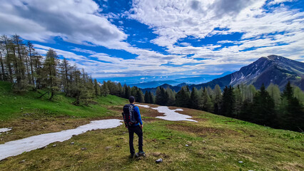 Obraz premium Man admiring the scenic view near Frauenkogel on the mountain peaks in the Karawanks, Carinthia, Austria. Borders Austria, Slovenia, Italy. Triglav National Park. Looking on Kahlkogel (Golica).