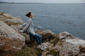 Naklejka na ściany i meble pretty woman sweaters cloudy sea admiring nature Relaxation concept