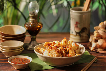 Crispy pork crackling decorated in wooden table with sauce ingredient and oil lamp for food...