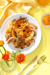 Crispy fish crackling decorated in yellow table with ingredient and flower for food advertising 