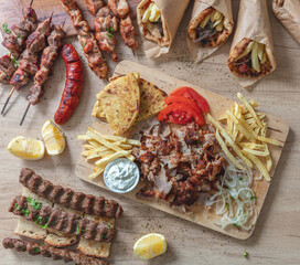 Greek traditional street food, gyro sliced meat, souvlaki, kebab on wooden table, top view