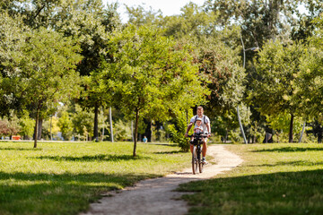 A father and son riding a bicycle in nature and living healthy life on earth's day.