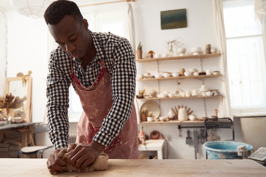 Experienced potter eliminating excess air bubbles during kneading process