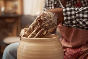 Potter making ceramic vessel in his workshop