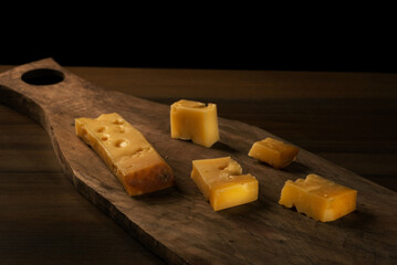 Sliced Kars Gruyere cheese on a wooden cutting board