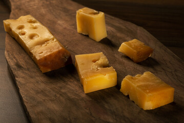 Sliced Kars Gruyere cheese on a wooden cutting board