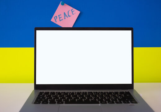 Flag of Ukraine on the background and wide digital screen of laptop for text or message. War with Russia. Cyber attack, sanctions, economic collapse. Message for world peace
