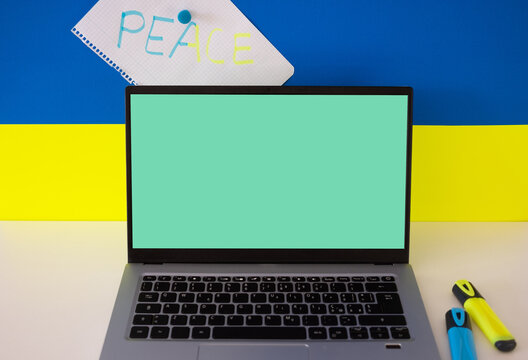Flag of Ukraine on the background and wide digital screen of laptop for text or message. War with Russia. Cyber attack, sanctions, economic collapse. Message for world peace - Powered by Adobe