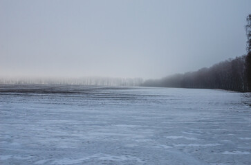 Melting snow on a plowed field. Strong fog. Spring time