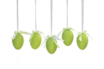 Five green Easter eggs hanging on white ribbons isolated on a white background. 