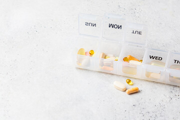 Pills box for daily intake of vitamins and medicines, copy space. Different capsules and tablets in...