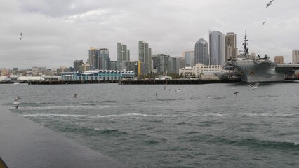 Downtown city skyline, San Diego cityscape, California USA. Waterfront highrise skyscrapers by bay. Urban architecture by harbor. Towers of financial district in Gaslamp Quarter. Overcast weather.