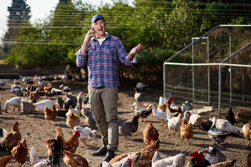 farmer talking on the phone at a chicken farm