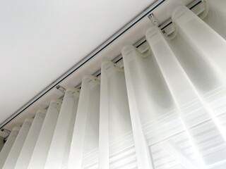 White sheer curtains with translucent fabric hanging on window