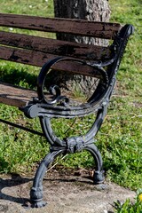 Vieux banc en bois avec son armature en fer forgé au bord d'un chemin à l'entrée d'un village