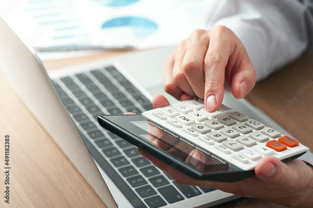 Aufkleber Working with calculator. Close up of hands. Laptop and reports on desk. Finance and calculating image.