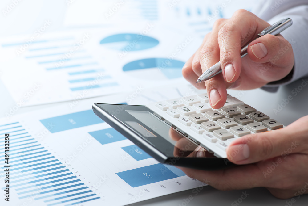 Poster financial analysis concept. working with calculator. close up of hands. many reports on desk.