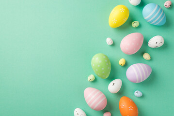 Fototapeta na wymiar Top view photo of easter decorations multicolored easter eggs on isolated pastel green background with copyspace