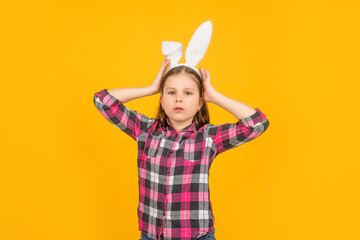 easter child in bunny ears on yellow background