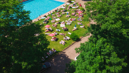 aerial view of people resting sunbathing near city pool