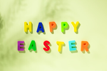 Greeting card with text multicolored HAPPY EASTER on green background