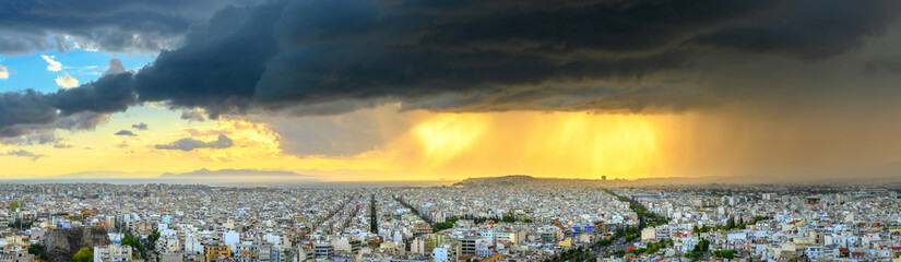 Aerial drone panoramic view of the Greek capital Athens at sunset with a sky overcast with storm clouds, Greece, Europe. View of the city from above
