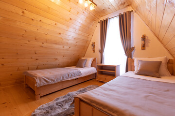 Interior of a wooden mountain house attic two bed bedroom