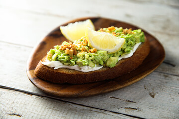 Homemade avocado toast with cream cheese and lemon