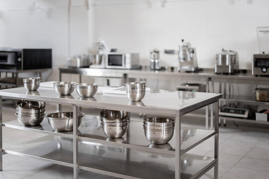 Professional restaurant kitchen with kitchen equipment and stainless steel tables. Interior with no people