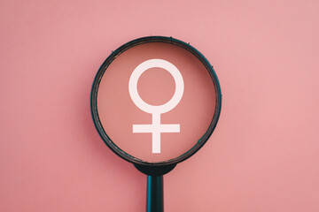 Women’s History Month concept.,View through a magnifying glass on White female sign icon over...